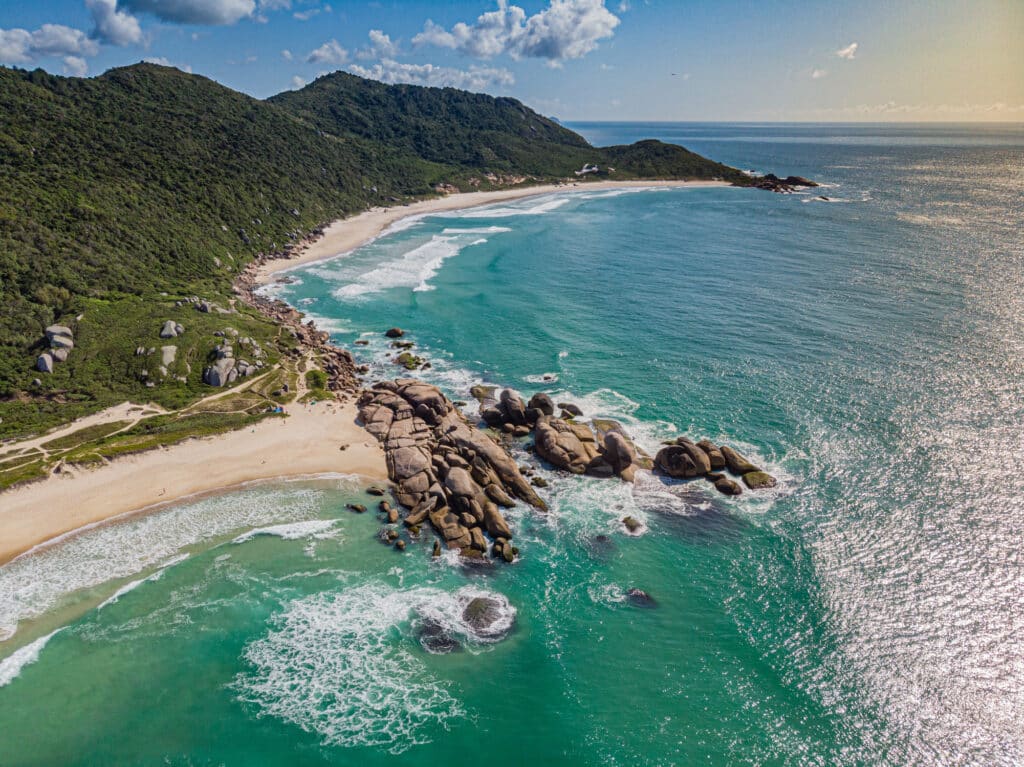 Vue plongeante sur les rochers de Ponta do Meio qui séparent la Praia Mole (1er plan à g.) de Galheta (Florianópolis, Brésil)//Uma vista aérea das rochas da Ponta do Meio que separa a Praia Mole (em primeiro plano à esquerda) da Galheta (Florianópolis, Santa Catarina, Brasil).