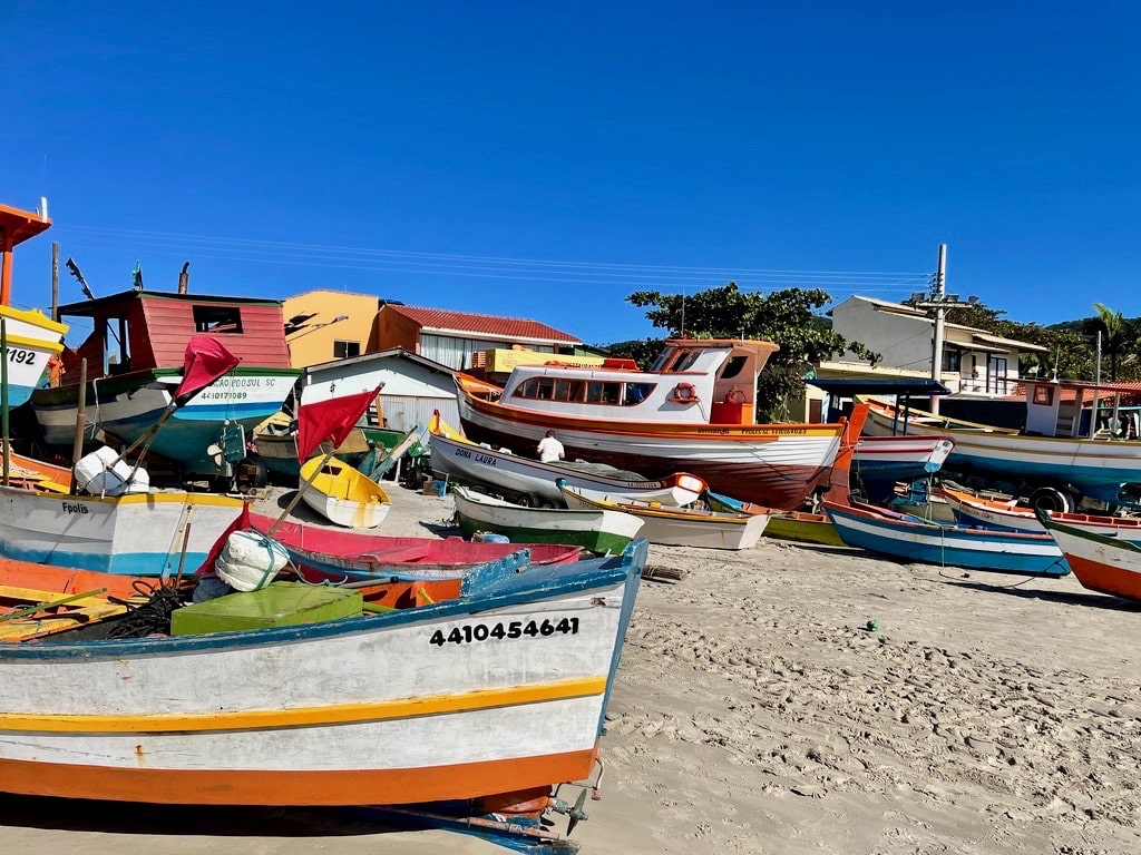 Retour au point de départ de cette randonnée, la Praia da Armação, où s’y accumulent, faute de place, les bateaux de pêche des locaux – une activité familiale et artisanale qui se pratique ici depuis 1732/De volta ao ponto de partida desta caminhada, a Praia da Armação onde, devido à falta de espaço, se acumulam os barcos de pesca dos locais - uma atividade familiar e artesanal que se pratica aqui desde 1732 (Florianópolis, Santa Catarina, Brasil).