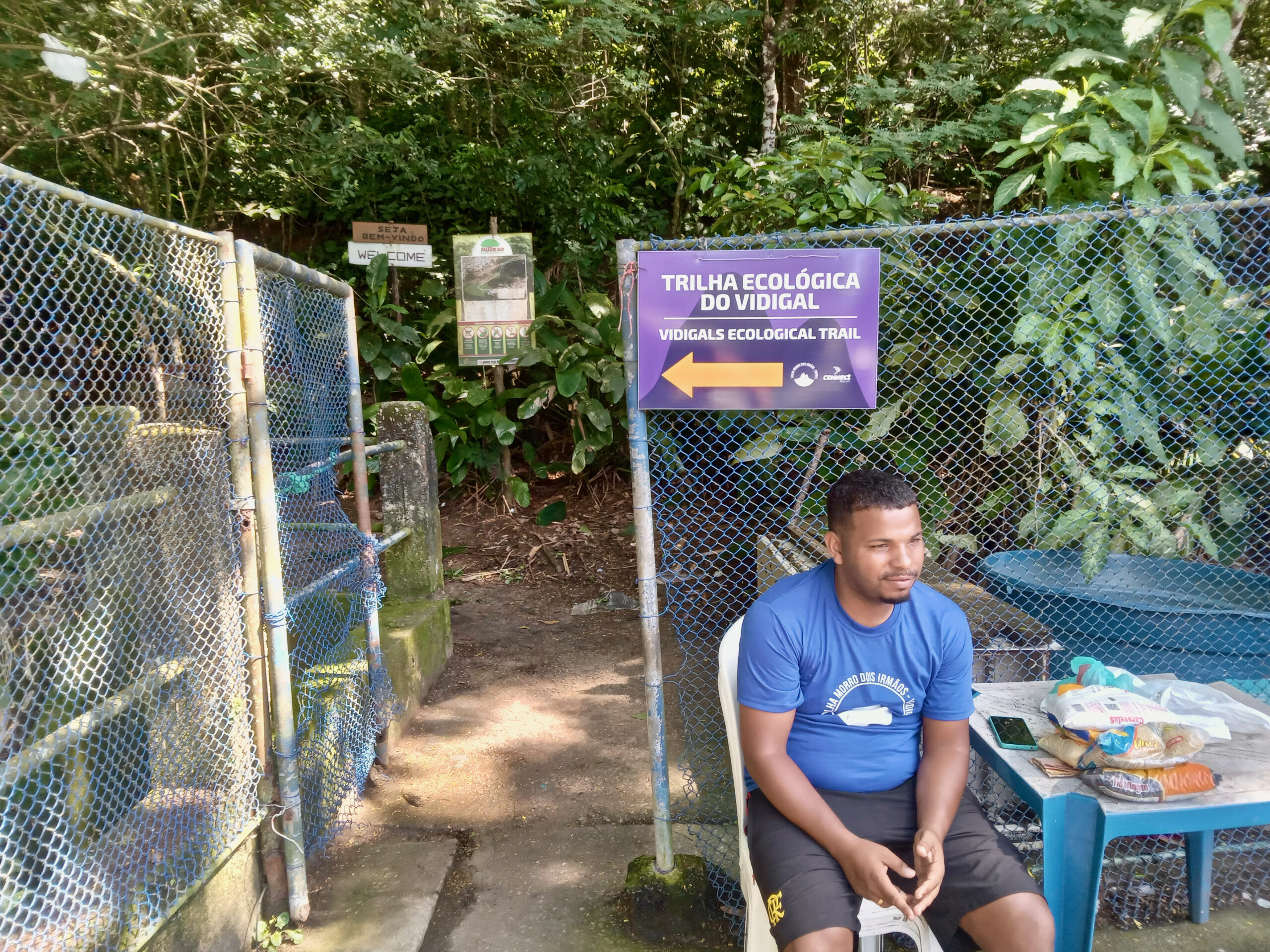 L'entrée (à gauche, derrière le terrain de foot) de la trilha ecológica do Vidigal, devant laquelle vous accueille un habitant de la favela.