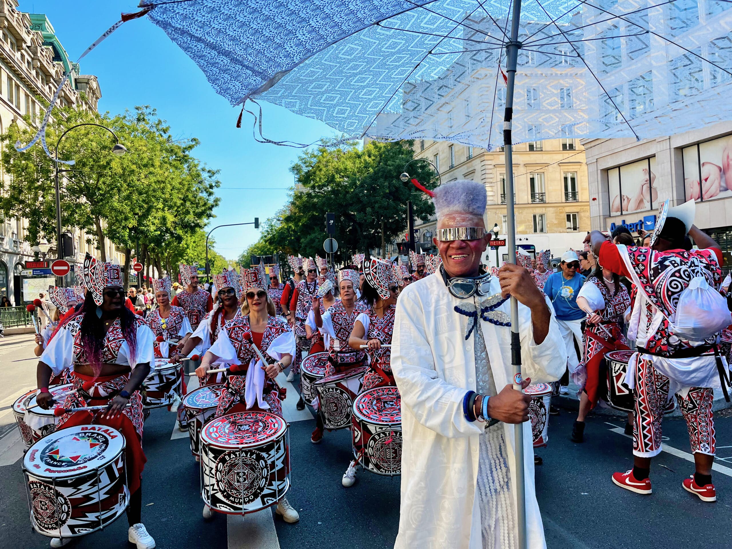 Paris à l'heure du Brésil a vibré dimanche 15 septembre au rythme du Festival du lavage de la Madeleine, le plus grand événement de cultures brésiliennes d’Europe. Animé par les batucadas, ce défilé inspiré par le Lavagem do Bonfim de Salvador de Bahia a traversé les Grands Boulevards jusqu’à la Madeleine. Carlinhos Brown a rejoint les Baianas sur les marches de l’église pour participer à ce rituel accompagné de prières et d’invocations aux orishas, les divinités du candomblé mises à l’honneur dans cette célébration festive mêlant spiritualité, musique et danse.