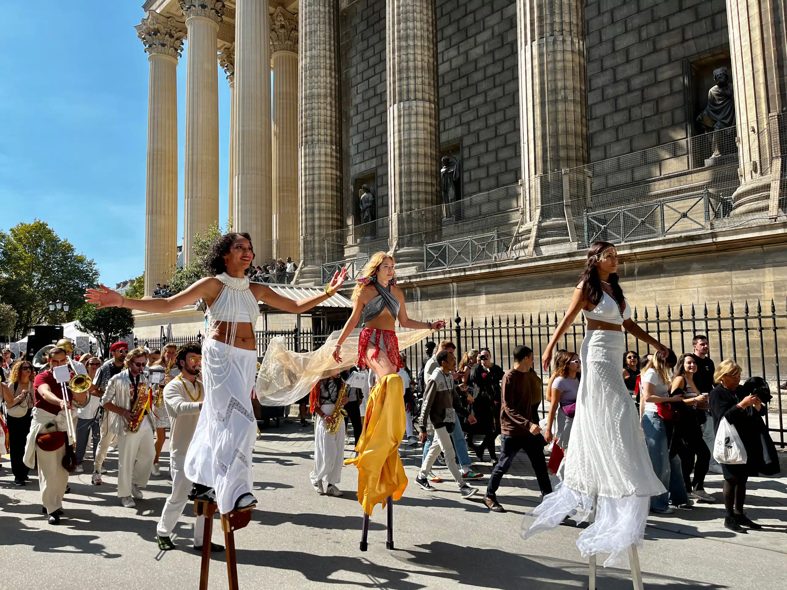 Composé de badauds, de musiciens et de danseuses sur échasses du Cabaret Gandaia, le premier cortège du Festival du lavage de la Madeleine arrive devant l'églisé.